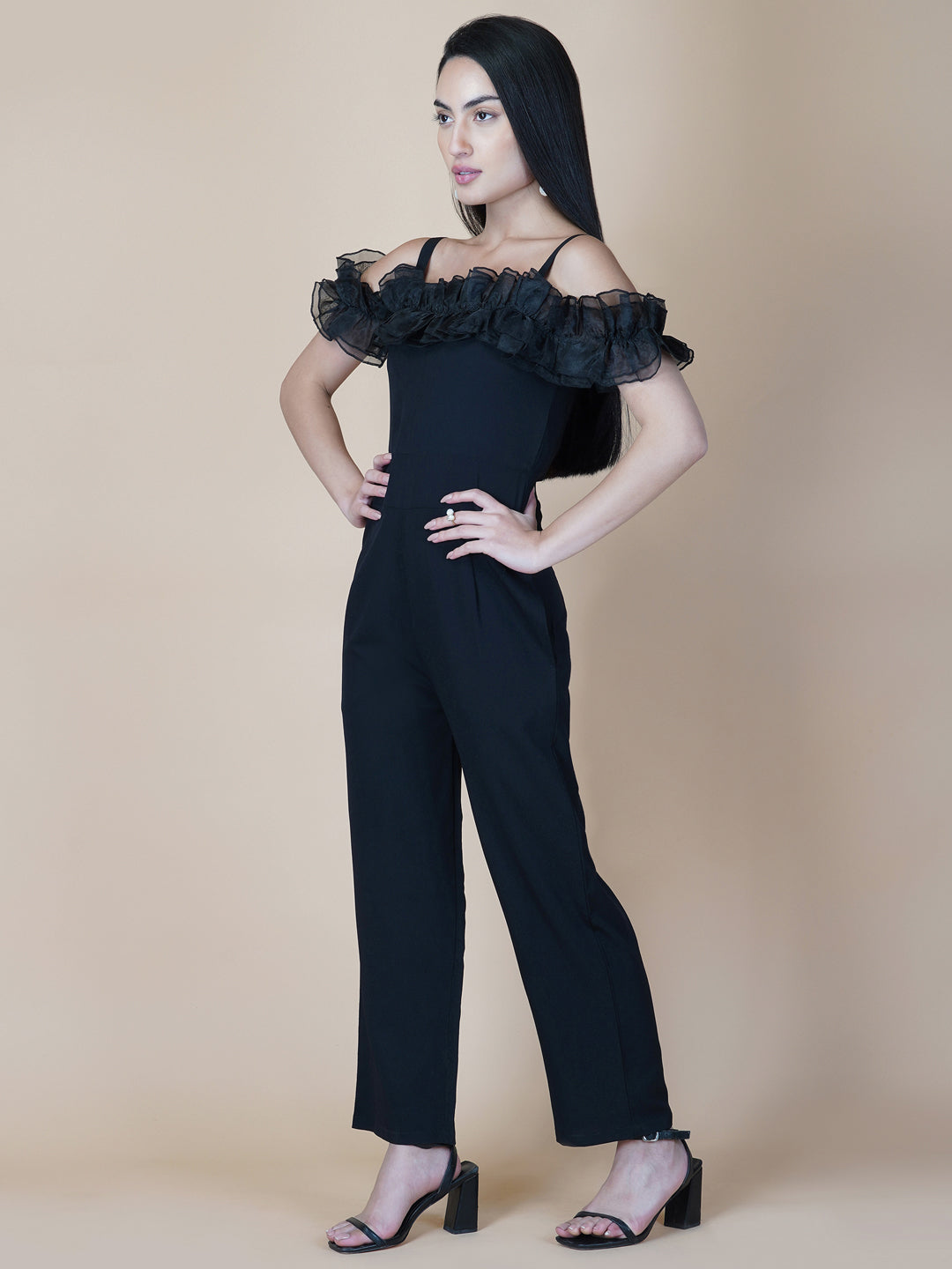 This black solid women's jumpsuit is the perfect combination of comfort and style. This jumpsuit features a tissue ruffle that adds a touch of feminine charm to the outfit. The jumpsuit has a sleeveless design with strap on shoulder, providing a stylish look