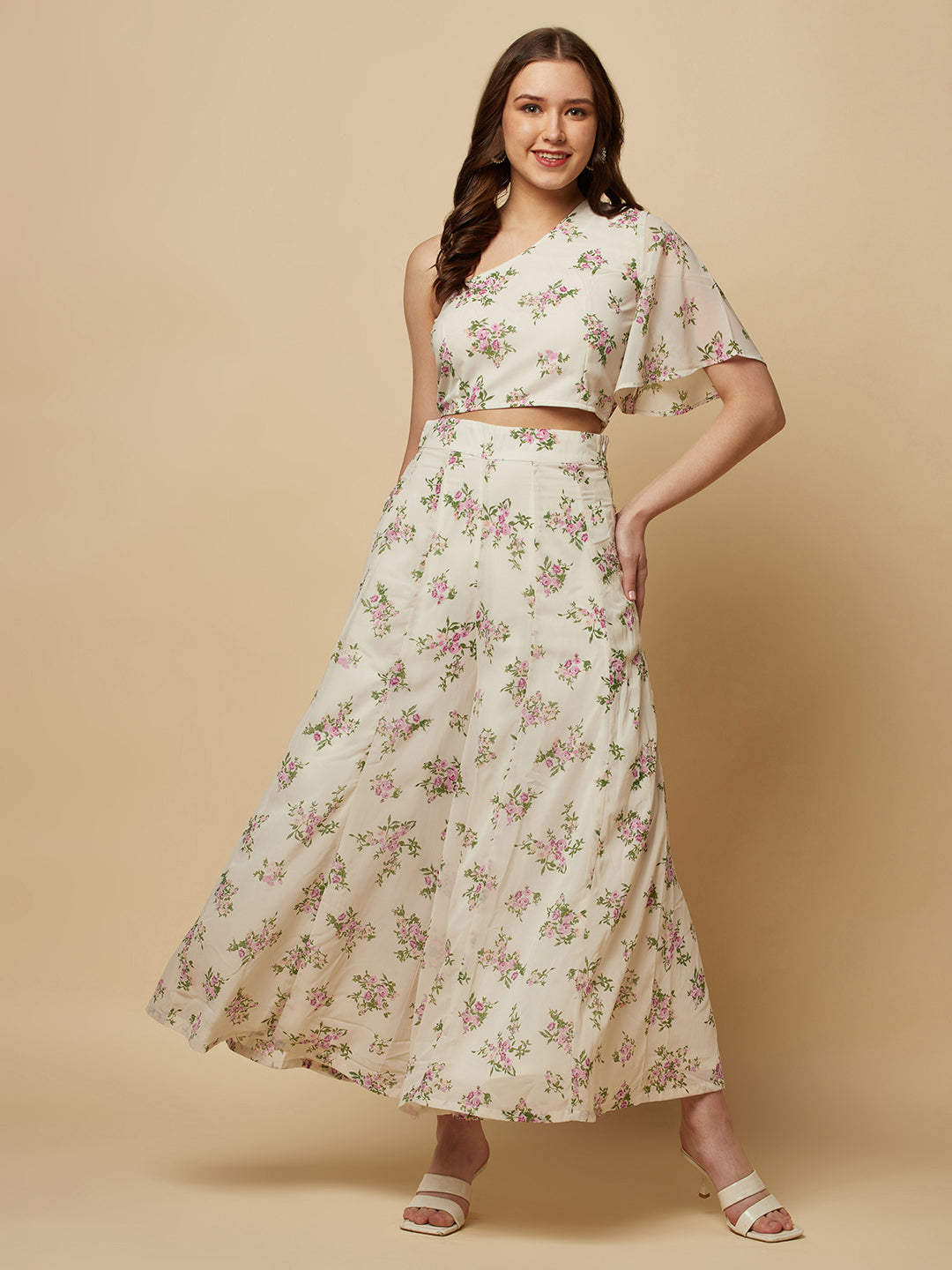 The White Floral Printed Palazzo With One Shoulder Crop Top Co-ords is a stylish and elegant outfit designed for women. This set features a white palazzo pant and a one-shoulder crop top, both adorned with a beautiful floral print in shades of pink, white, and green. The palazzo pants are made of a lightweight and breathable fabric that flows elegantly as you move, providing both comfort and style.