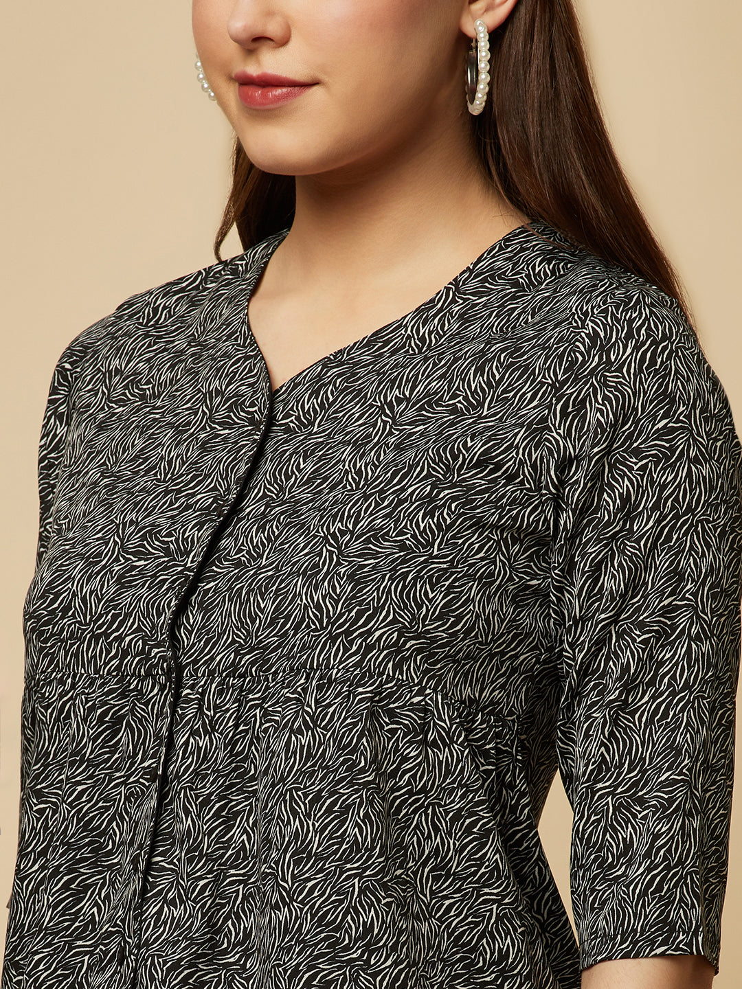 A black printed top with a front placket and ruched bust line is a stylish and elegant piece of clothing. The top has a simple and classic design with a front placket that adds a touch of sophistication to the outfit. The ruched bust line creates a flattering and feminine look, enhancing the wearer's curves.