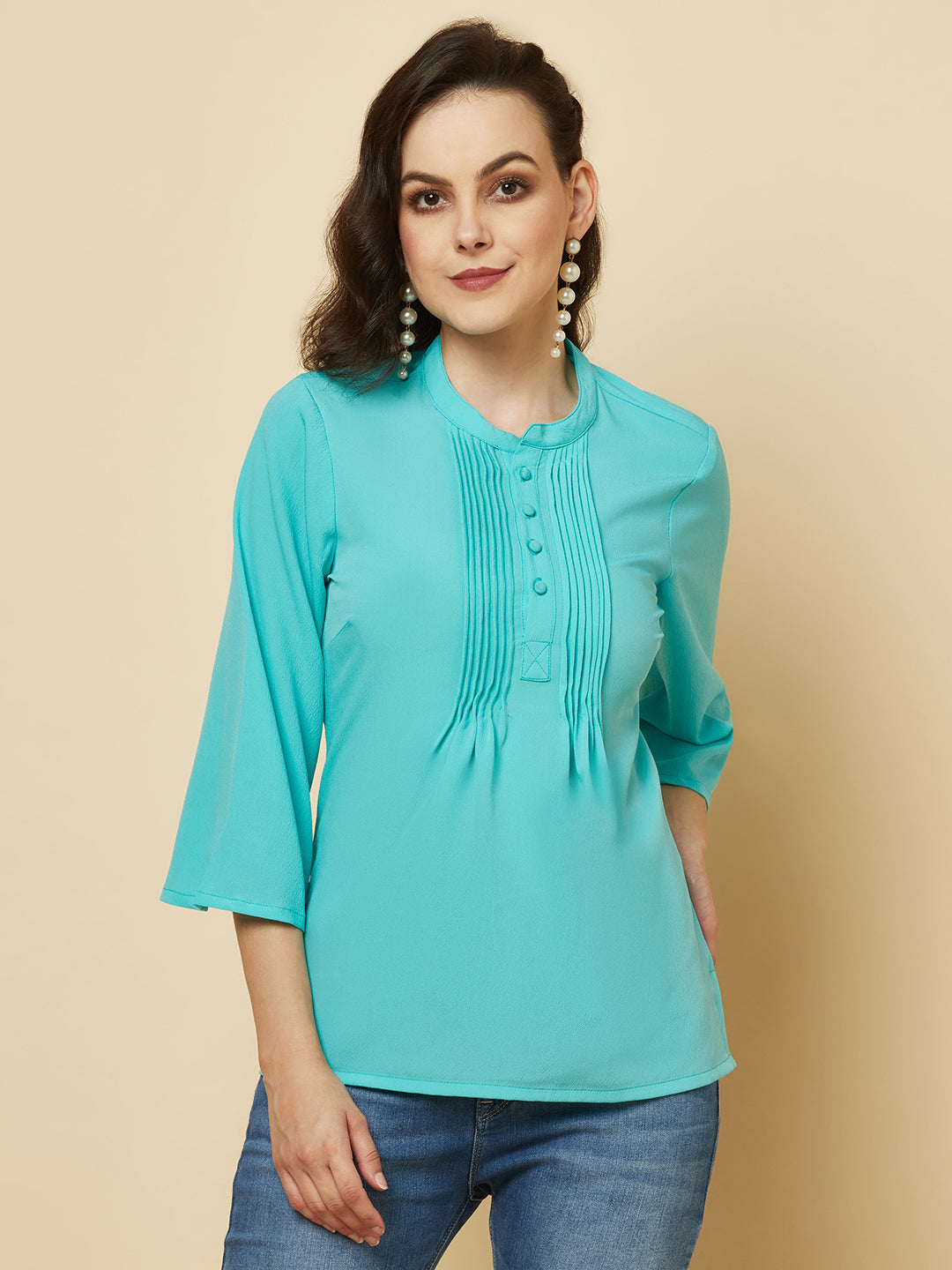 This beautiful top features a vibrant turquoise hue that's perfect for adding a pop of color to any outfit. The pintuck detailing adds a touch of elegance, while the comfortable and breathable fabric ensures that you'll feel great all day long. Whether you're heading to the office or out for a night on the town, this top is sure to turn heads and make you feel confident and beautiful. 