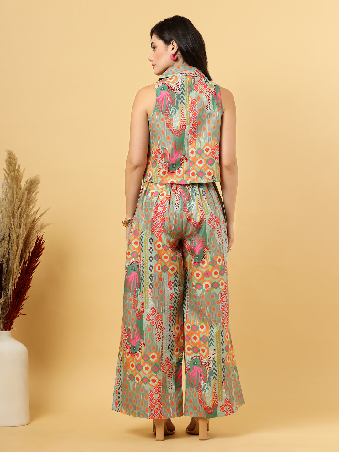 Elevate your ethnic style with this chic 2-piece co-ordinate set for women. The sleeveless top features a beautiful ethnic print with a tailored collar neck and a front button closure for a polished look. Paired with wide-leg pants designed with an elasticated waist, front pleats, and two handy side pockets—this set combines comfort with contemporary flair. Perfect for festive outings or casual gatherings.