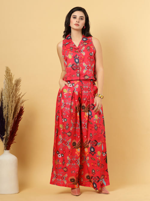 Woman in a red floral top & matching wide Leg pants outfit holding a pink handbag against a beige background.