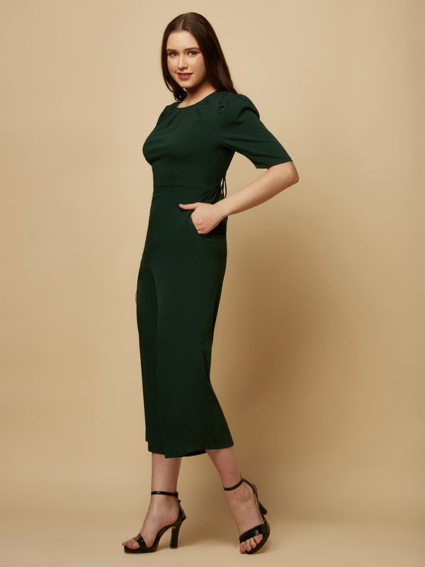 Introducing our stunning Green solid Women Jumpsuit With Back Waist Cut and Draw String, the perfect addition to your wardrobe for a stylish and comfortable look. This jumpsuit features a unique pattern that is sure to turn heads and make you stand out from the crowd.  Crafted from high-quality materials, this jumpsuit is both soft and durable, making it perfect for all-day wear.