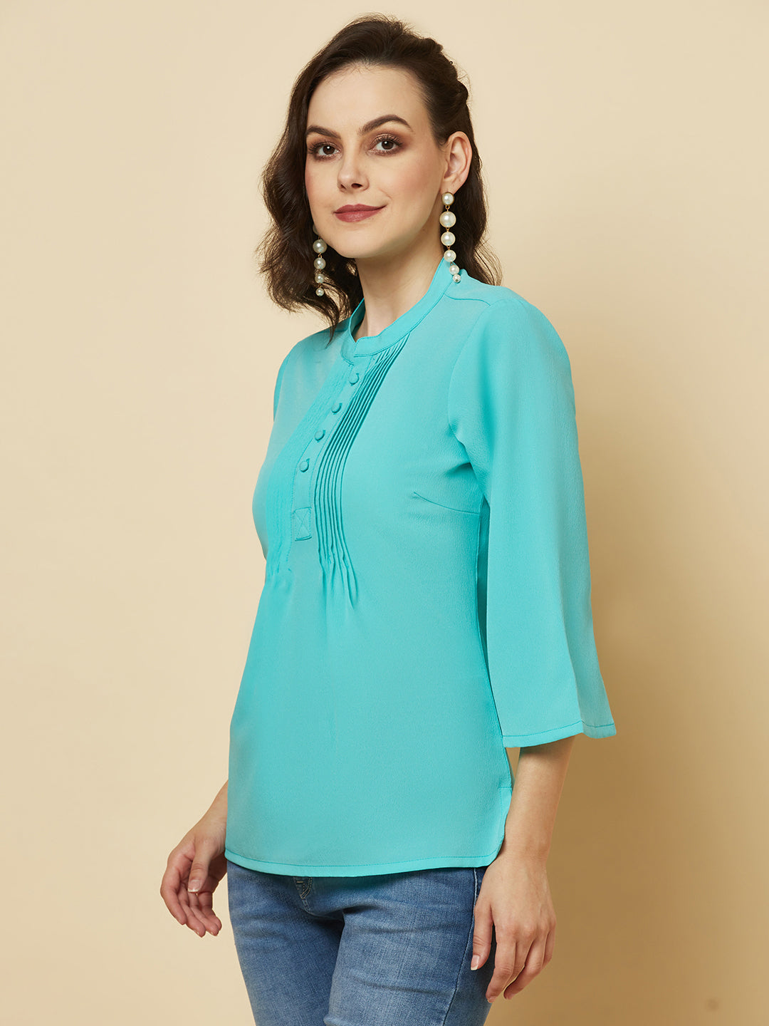 This beautiful top features a vibrant turquoise hue that's perfect for adding a pop of color to any outfit. The pintuck detailing adds a touch of elegance, while the comfortable and breathable fabric ensures that you'll feel great all day long. Whether you're heading to the office or out for a night on the town, this top is sure to turn heads and make you feel confident and beautiful. 