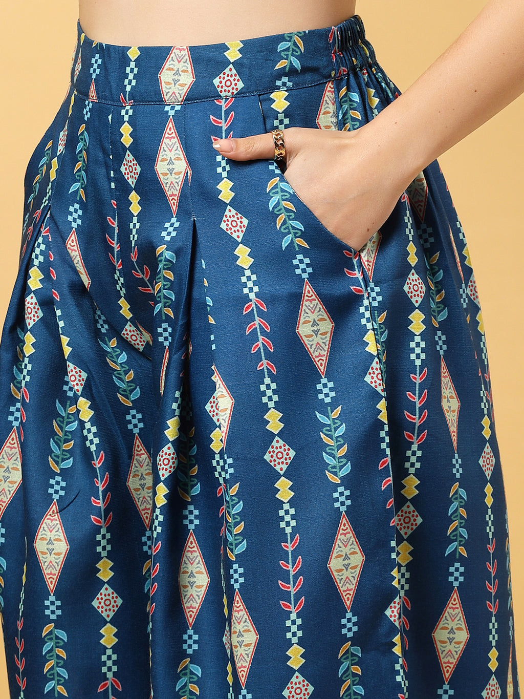 Elevate your ethnic style with this chic 2-piece co-ordinate set for women. The sleeveless top features a beautiful ethnic print with a tailored collar neck and a front button closure for a polished look. Paired with wide-leg pants designed with an elasticated waist, front pleats, and two handy side pockets—this set combines comfort with contemporary flair. Perfect for festive outings or casual gatherings.
