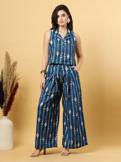 Elevate your ethnic style with this chic 2-piece co-ordinate set for women. The sleeveless top features a beautiful ethnic print with a tailored collar neck and a front button closure for a polished look. Paired with wide-leg pants designed with an elasticated waist, front pleats, and two handy side pockets—this set combines comfort with contemporary flair. Perfect for festive outings or casual gatherings.