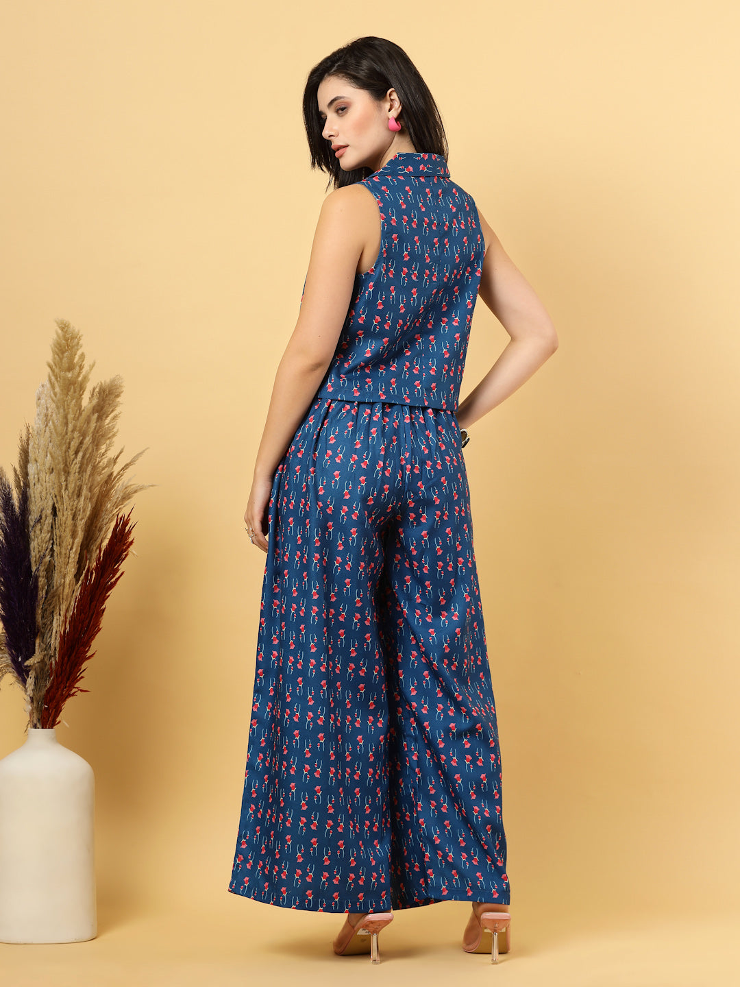 Elevate your ethnic style with this chic 2-piece co-ordinate set for women. The sleeveless top features a beautiful ethnic print with a tailored collar neck and a front button closure for a polished look. Paired with wide-leg pants designed with an elasticated waist, front pleats, and two handy side pockets—this set combines comfort with contemporary flair. Perfect for festive outings or casual gatherings.