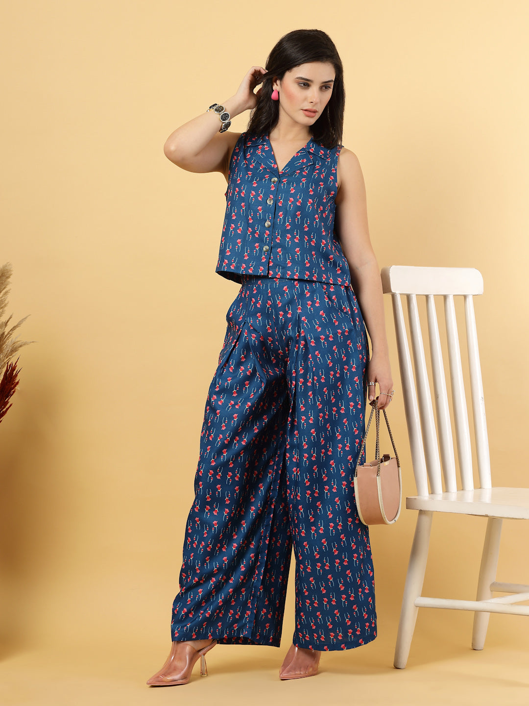 Elevate your ethnic style with this chic 2-piece co-ordinate set for women. The sleeveless top features a beautiful ethnic print with a tailored collar neck and a front button closure for a polished look. Paired with wide-leg pants designed with an elasticated waist, front pleats, and two handy side pockets—this set combines comfort with contemporary flair. Perfect for festive outings or casual gatherings.