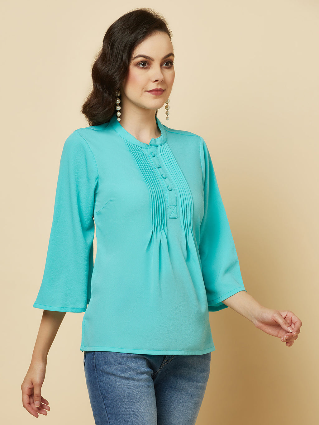 This beautiful top features a vibrant turquoise hue that's perfect for adding a pop of color to any outfit. The pintuck detailing adds a touch of elegance, while the comfortable and breathable fabric ensures that you'll feel great all day long. Whether you're heading to the office or out for a night on the town, this top is sure to turn heads and make you feel confident and beautiful. 
