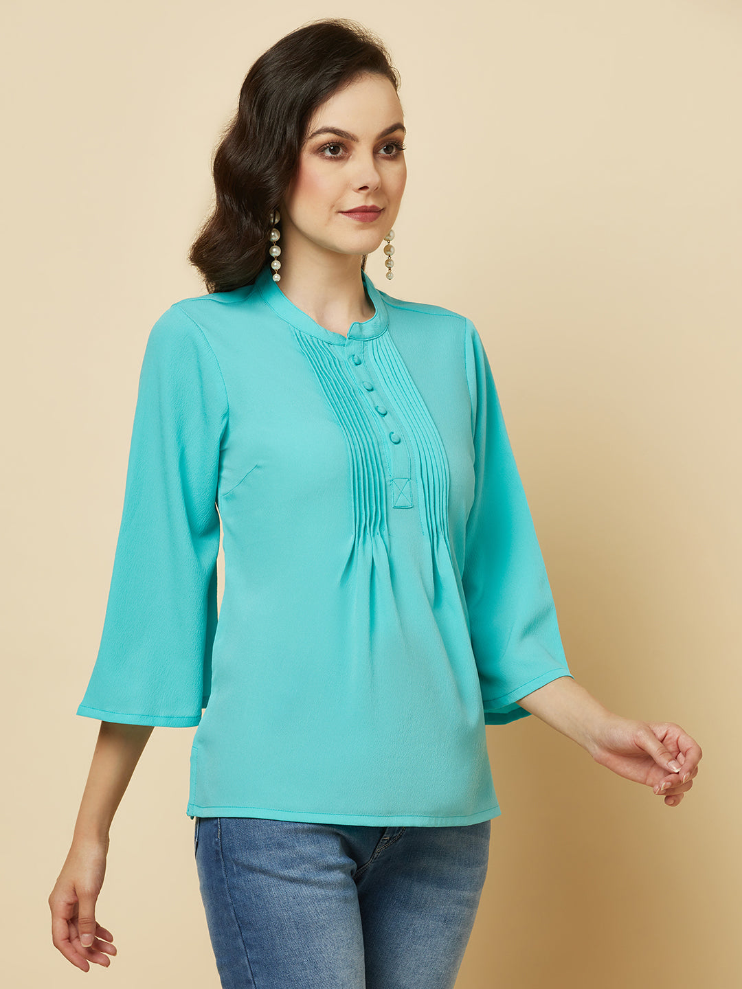 This beautiful top features a vibrant turquoise hue that's perfect for adding a pop of color to any outfit. The pintuck detailing adds a touch of elegance, while the comfortable and breathable fabric ensures that you'll feel great all day long. Whether you're heading to the office or out for a night on the town, this top is sure to turn heads and make you feel confident and beautiful. 