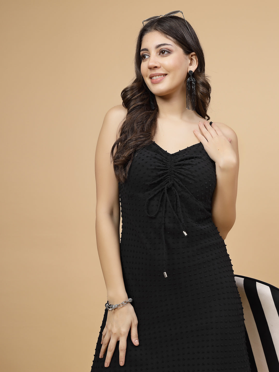 A stylish short Western dress in black color with a zip closure for easy wear. The dress is adorned with ruched bust detailing, adding a fashionable touch. It comes with adjustable shoulder straps for a customizable fit. The presence of an attached lining enhances comfort and coverage, making it a chic and versatile wardrobe choice.