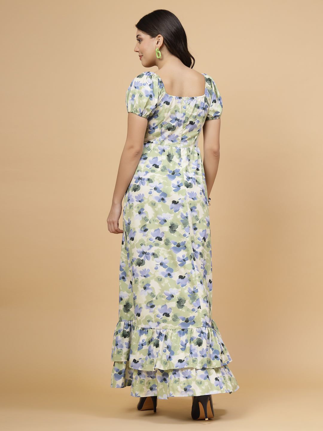 A floor-length casual maxi dress in a vibrant green color. The dress features ruched bust detailing with a drawstring for a customizable fit. It has elasticated shoulders, creating a comfortable and versatile style. The empire waist accentuates the figure, and a double ruffle adds a touch of flair. A front flare with a slit enhances mobility and style. The dress is secured with a zip closure for easy wear.