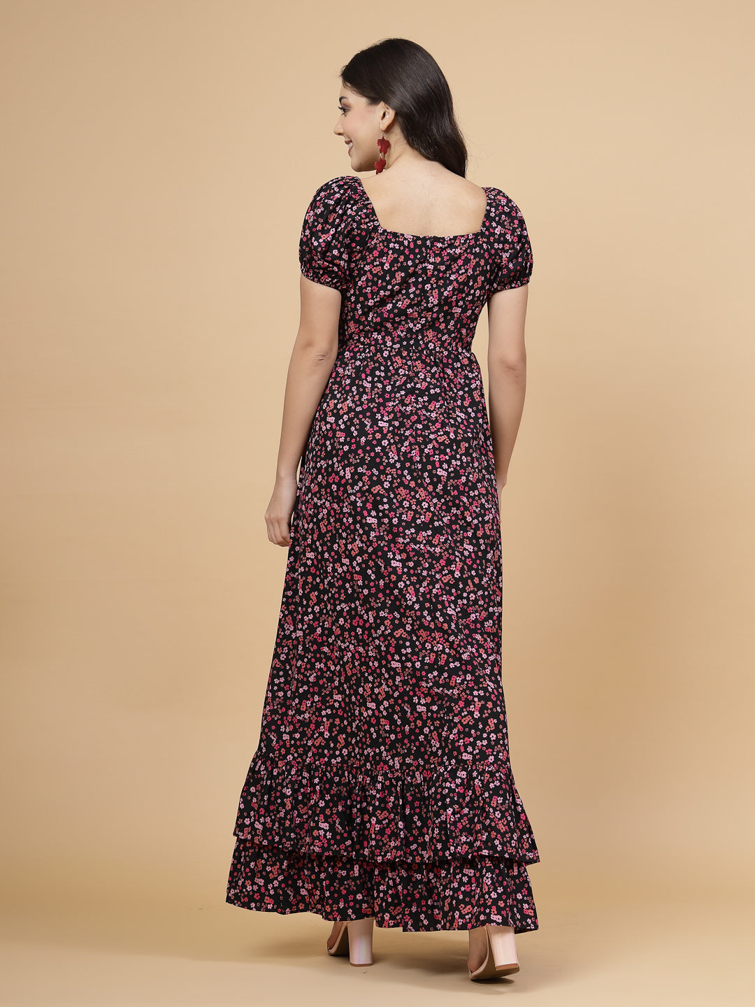A floor-length casual maxi dress in a vibrant pink color. The dress features ruched bust detailing with a drawstring for a customizable fit. It has elasticated shoulders, creating a comfortable and versatile style. The empire waist accentuates the figure, and a double ruffle adds a touch of flair. A front flare with a slit enhances mobility and style. The dress is secured with a zip closure for easy wear.