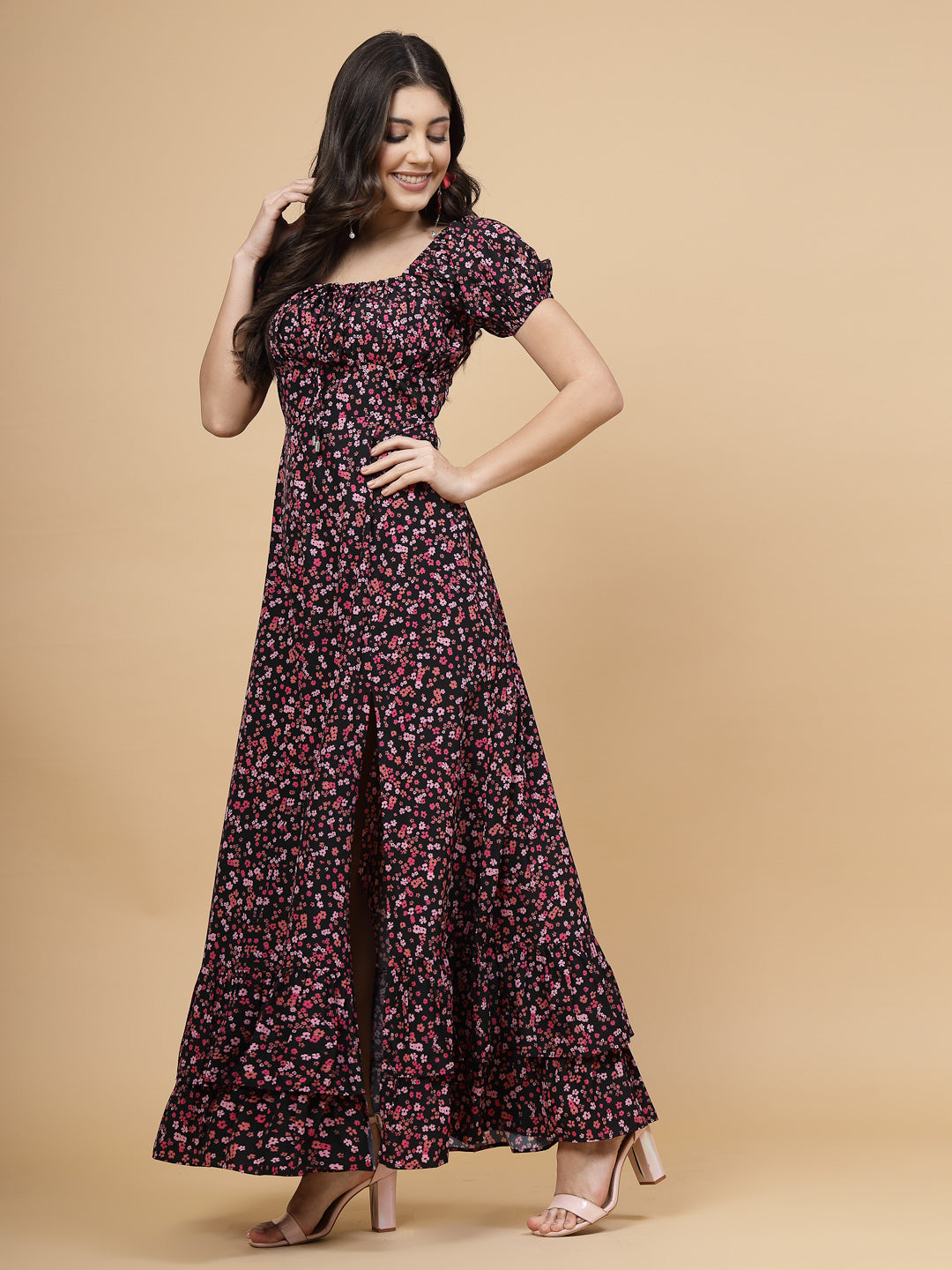 A floor-length casual maxi dress in a vibrant pink color. The dress features ruched bust detailing with a drawstring for a customizable fit. It has elasticated shoulders, creating a comfortable and versatile style. The empire waist accentuates the figure, and a double ruffle adds a touch of flair. A front flare with a slit enhances mobility and style. The dress is secured with a zip closure for easy wear.
