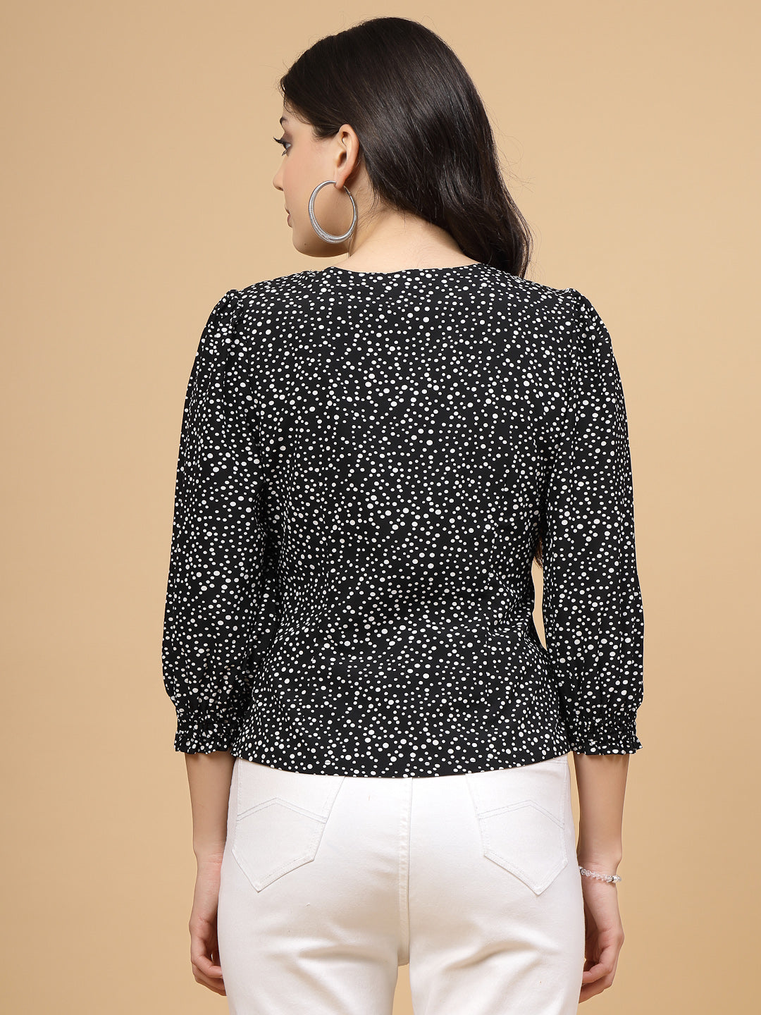 A  black printed puff sleeve blouse designed for a fashionable look. The blouse features a button closure at the front, allowing for easy wear. With 3/4 sleeves, it is a versatile and stylish choice, perfect for pairing with jeans to create a trendy ensemble.