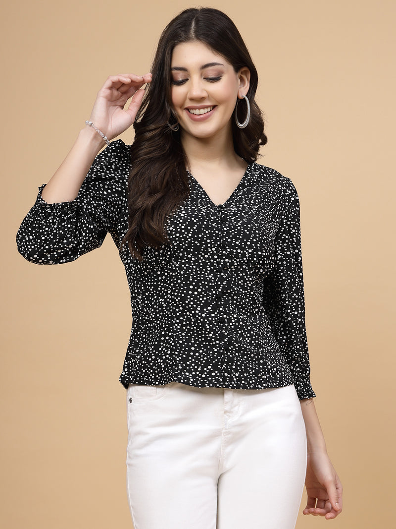 A  black printed puff sleeve blouse designed for a fashionable look. The blouse features a button closure at the front, allowing for easy wear. With 3/4 sleeves, it is a versatile and stylish choice, perfect for pairing with jeans to create a trendy ensemble.