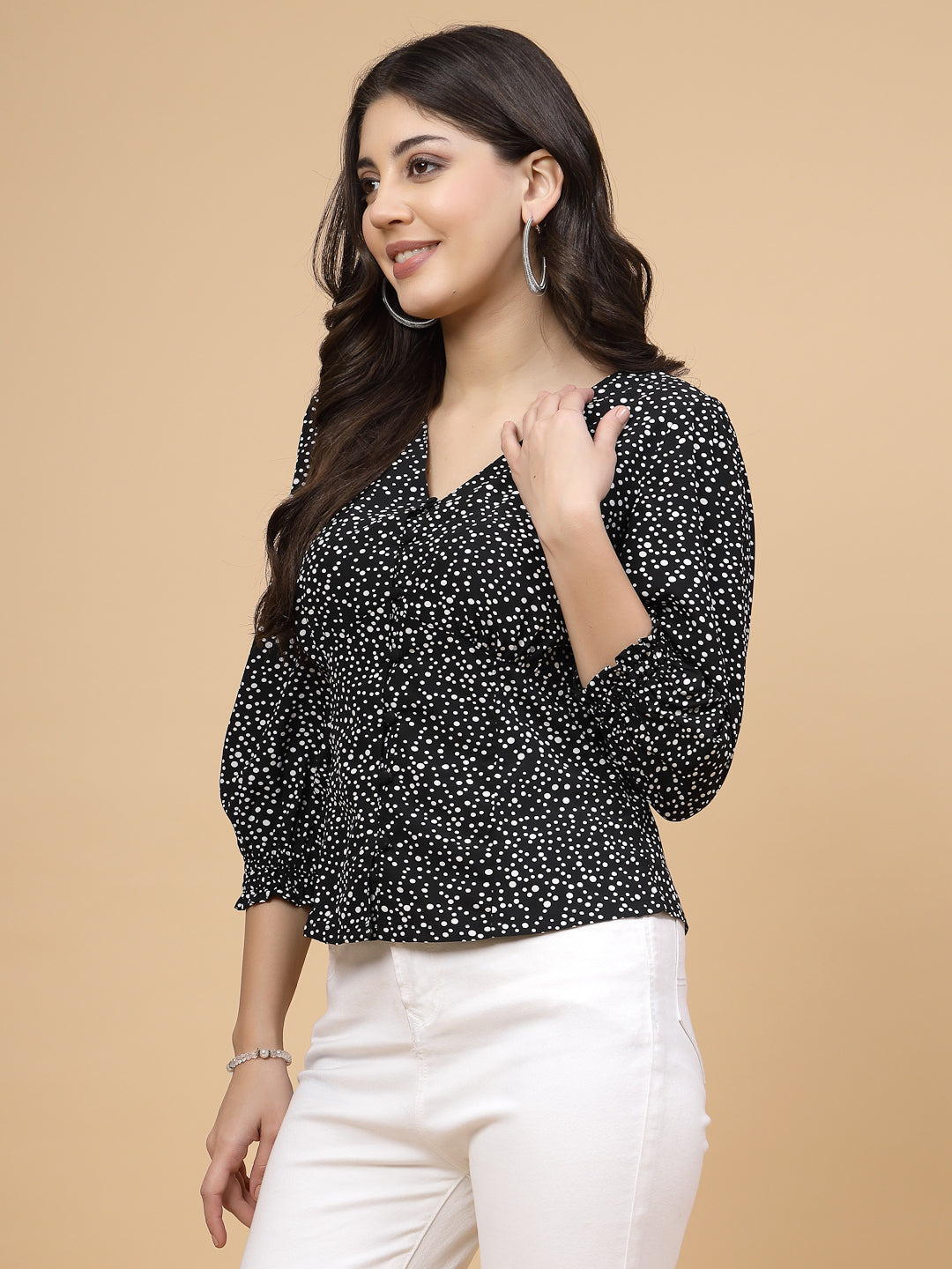 A  black printed puff sleeve blouse designed for a fashionable look. The blouse features a button closure at the front, allowing for easy wear. With 3/4 sleeves, it is a versatile and stylish choice, perfect for pairing with jeans to create a trendy ensemble.