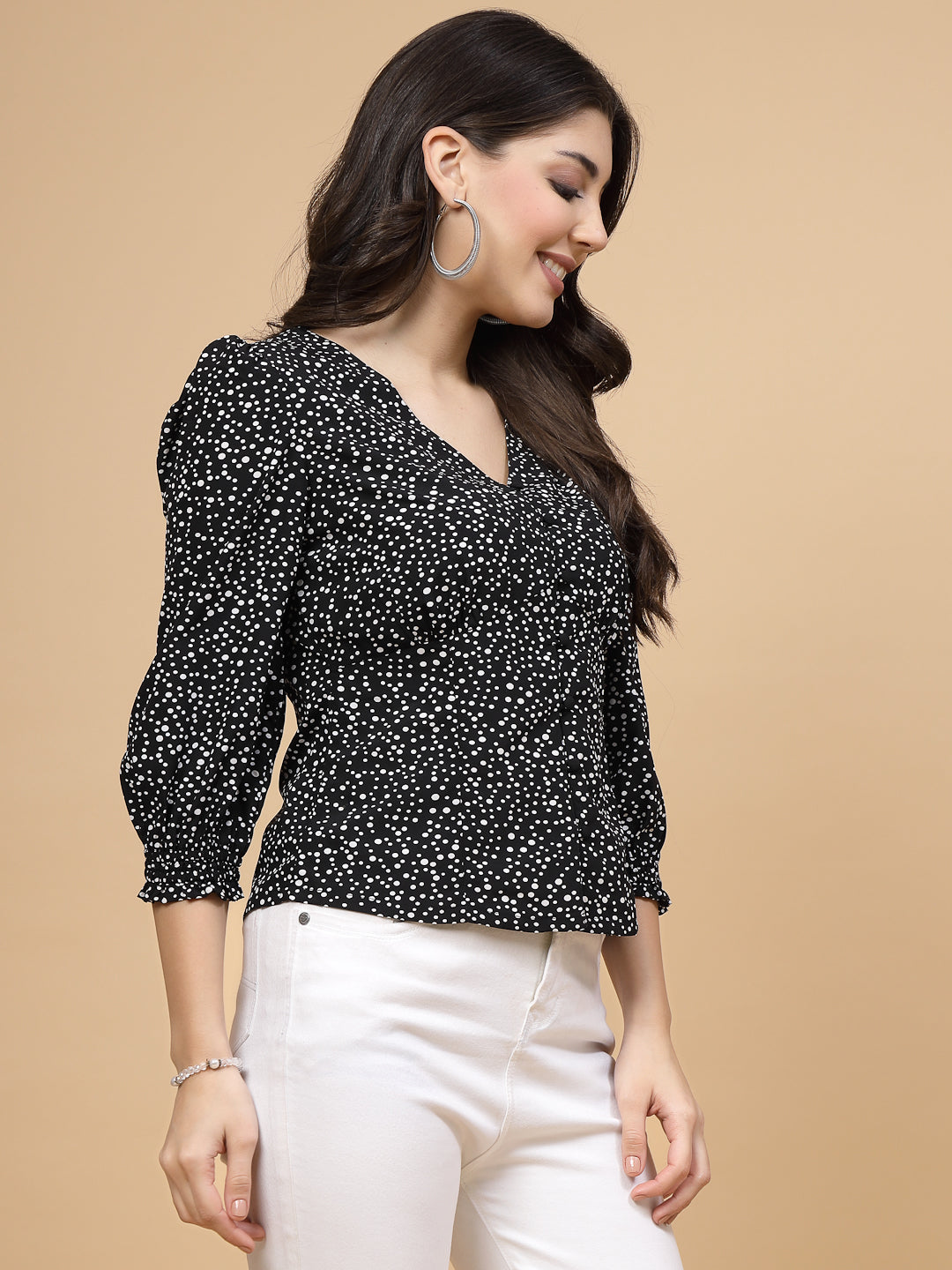 A  black printed puff sleeve blouse designed for a fashionable look. The blouse features a button closure at the front, allowing for easy wear. With 3/4 sleeves, it is a versatile and stylish choice, perfect for pairing with jeans to create a trendy ensemble.
