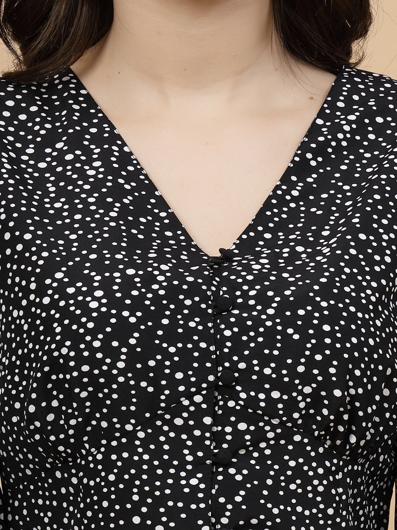 A  black printed puff sleeve blouse designed for a fashionable look. The blouse features a button closure at the front, allowing for easy wear. With 3/4 sleeves, it is a versatile and stylish choice, perfect for pairing with jeans to create a trendy ensemble.