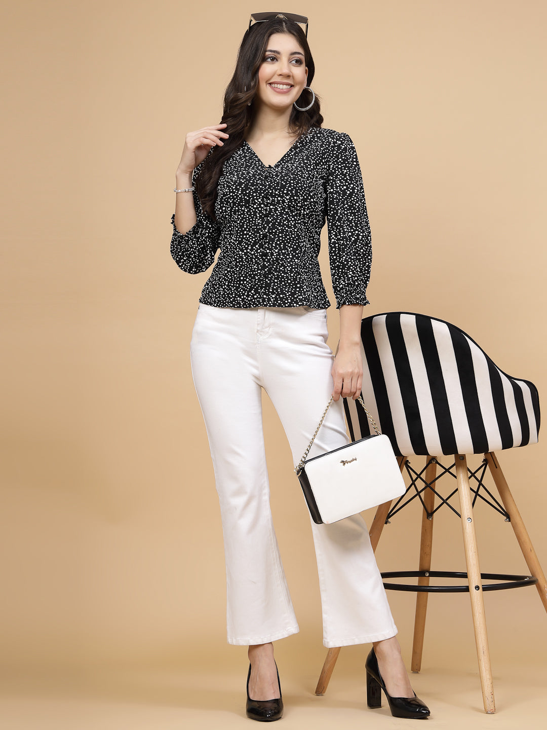 A  black printed puff sleeve blouse designed for a fashionable look. The blouse features a button closure at the front, allowing for easy wear. With 3/4 sleeves, it is a versatile and stylish choice, perfect for pairing with jeans to create a trendy ensemble.