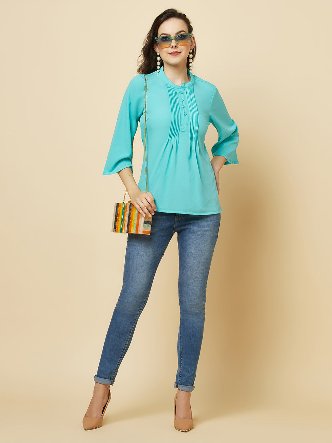 This beautiful top features a vibrant turquoise hue that's perfect for adding a pop of color to any outfit. The pintuck detailing adds a touch of elegance, while the comfortable and breathable fabric ensures that you'll feel great all day long. Whether you're heading to the office or out for a night on the town, this top is sure to turn heads and make you feel confident and beautiful. 