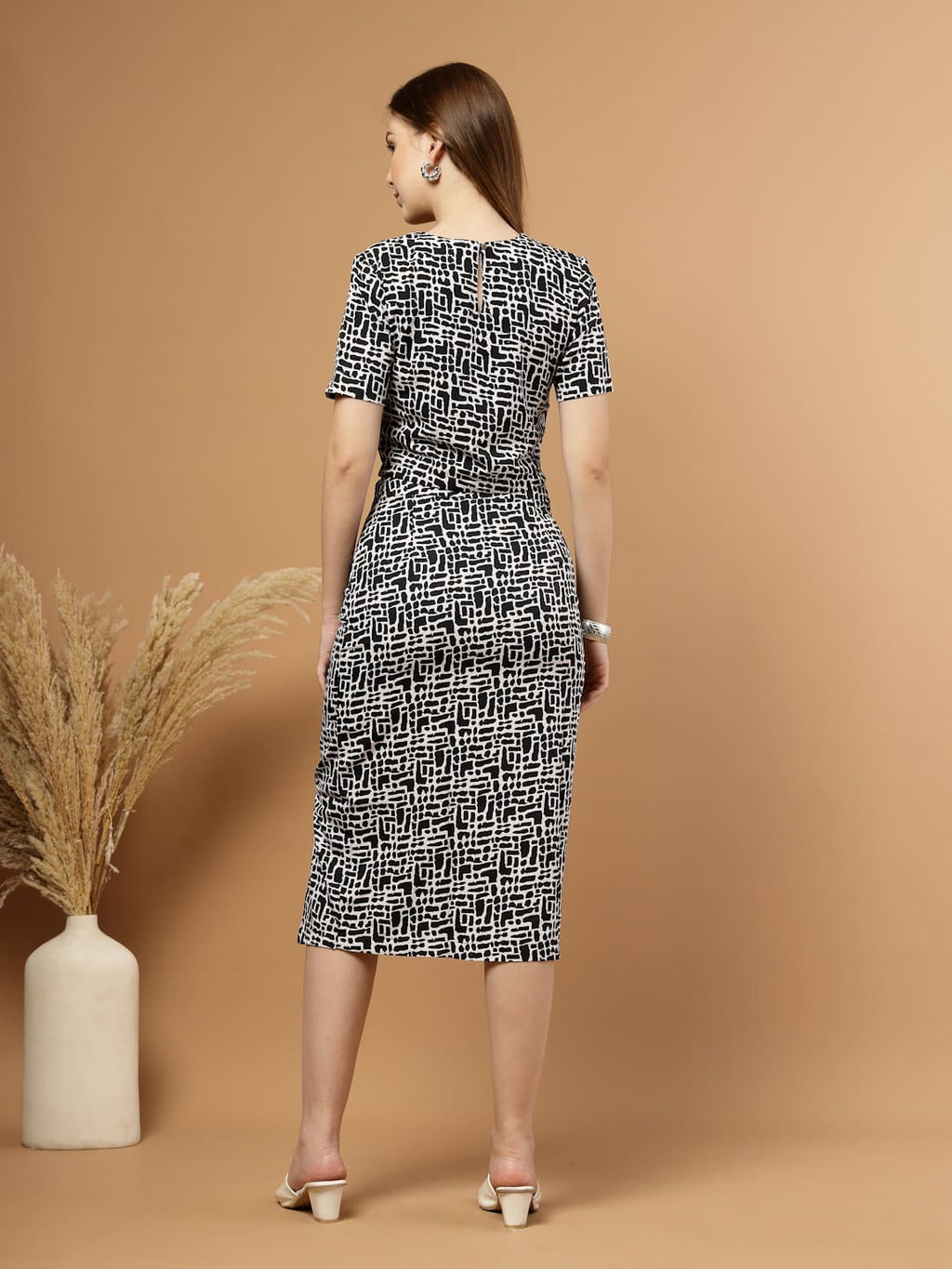 Black and white abstract printed women’s co-ord set featuring a blouson crop top paired with a straight skirt that has a stylish slit, perfect for a chic and modern look. back view