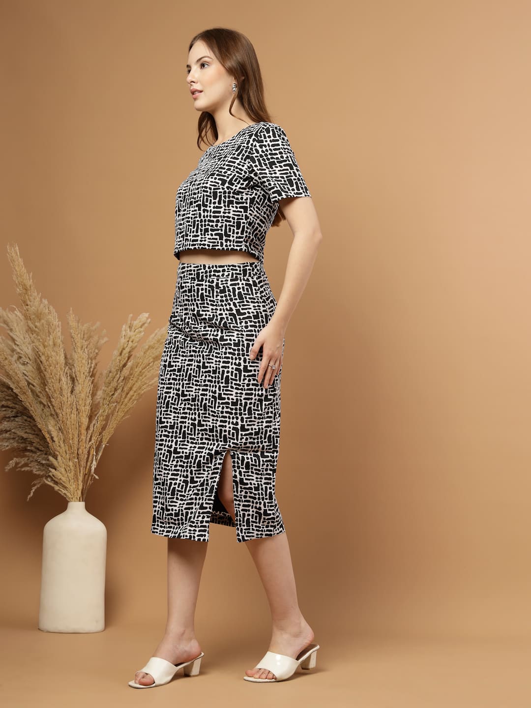 Black and white abstract printed women’s co-ord set featuring a blouson crop top paired with a straight skirt that has a stylish slit, perfect for a chic and modern look. Side view