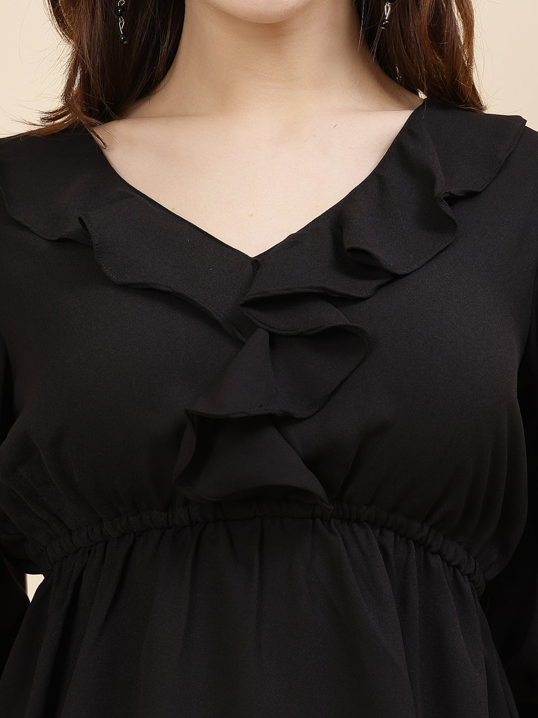 Black colour chic and sophisticated stylish top for women is a perfect blend of contemporary elegance and timeless charm. This exquisite piece features a beautifully ruffled neckline that adds a touch of romance and femininity to your ensemble. The ruched waist not only enhances your silhouette but also adds a modern twist, creating a flattering and fashionable look.