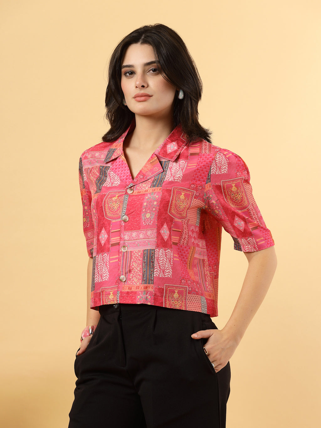 A woman is standing and posing with a printed coat collar top in a patterned design. 