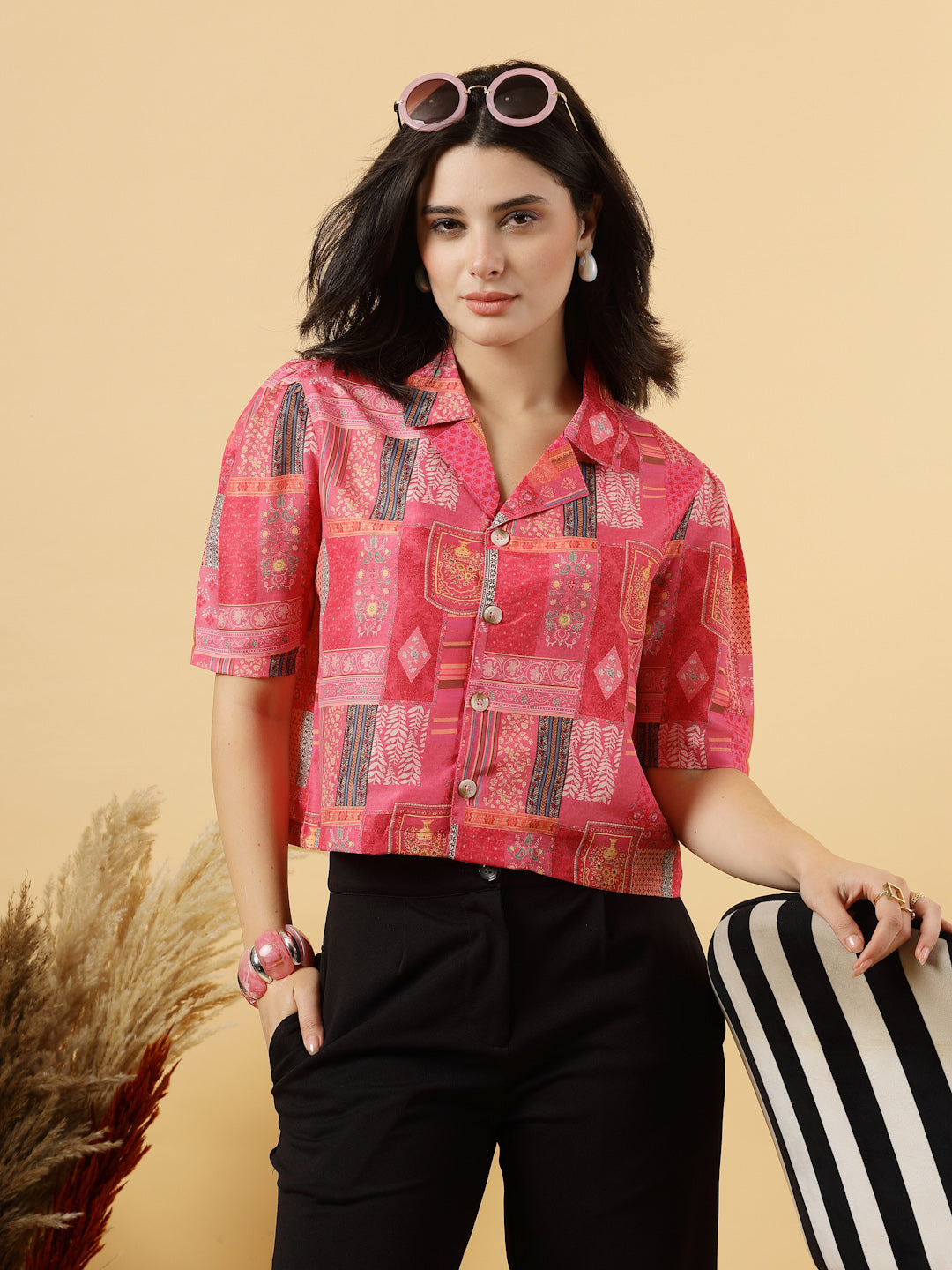 A woman is standing and posing with a printed coat collar top in a patterned design. 