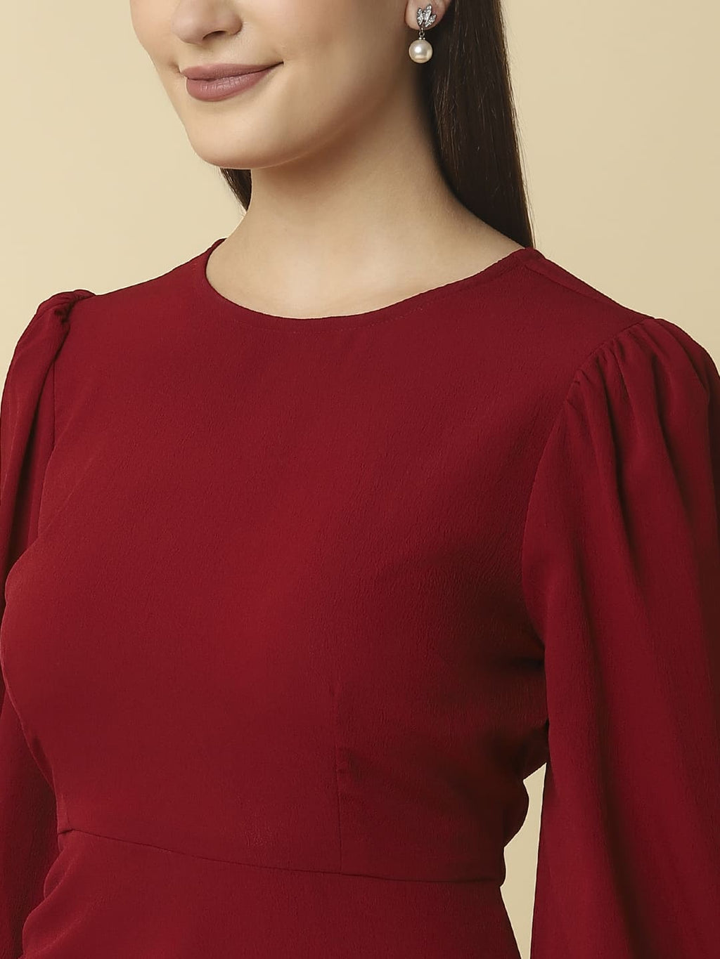Woman wearing Raassio maroon ruched short dress with long puff sleeves facing front close up