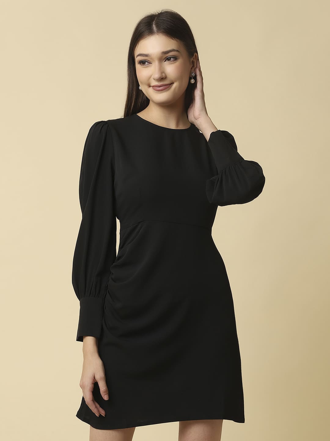 Woman wearing Raassio black ruched short dress with long puff sleeves facing front