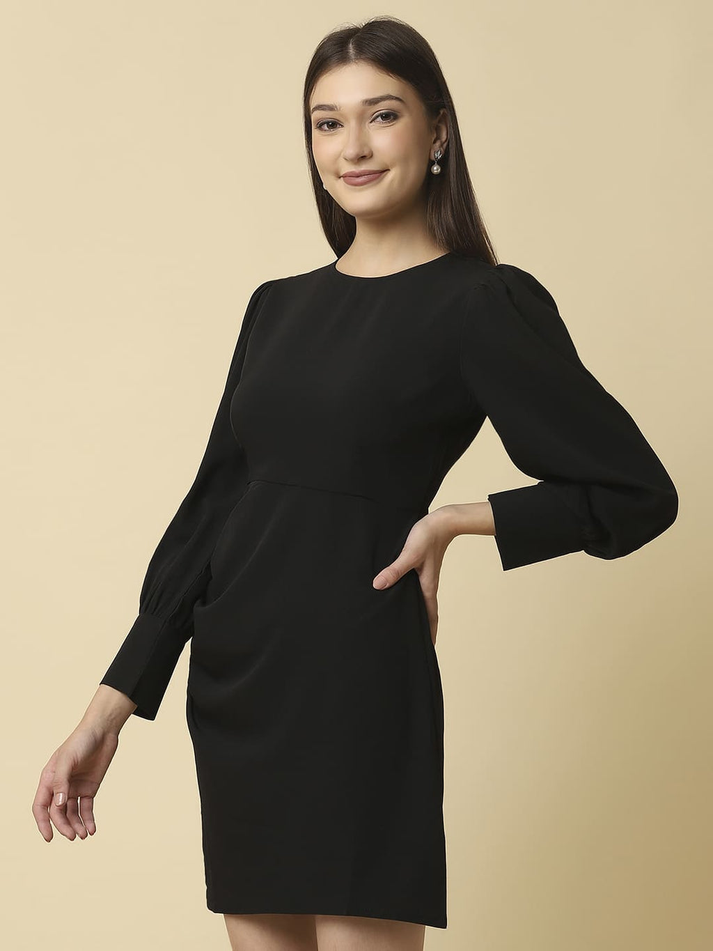 Woman wearing Raassio black ruched short dress with long puff sleeves facing front left side