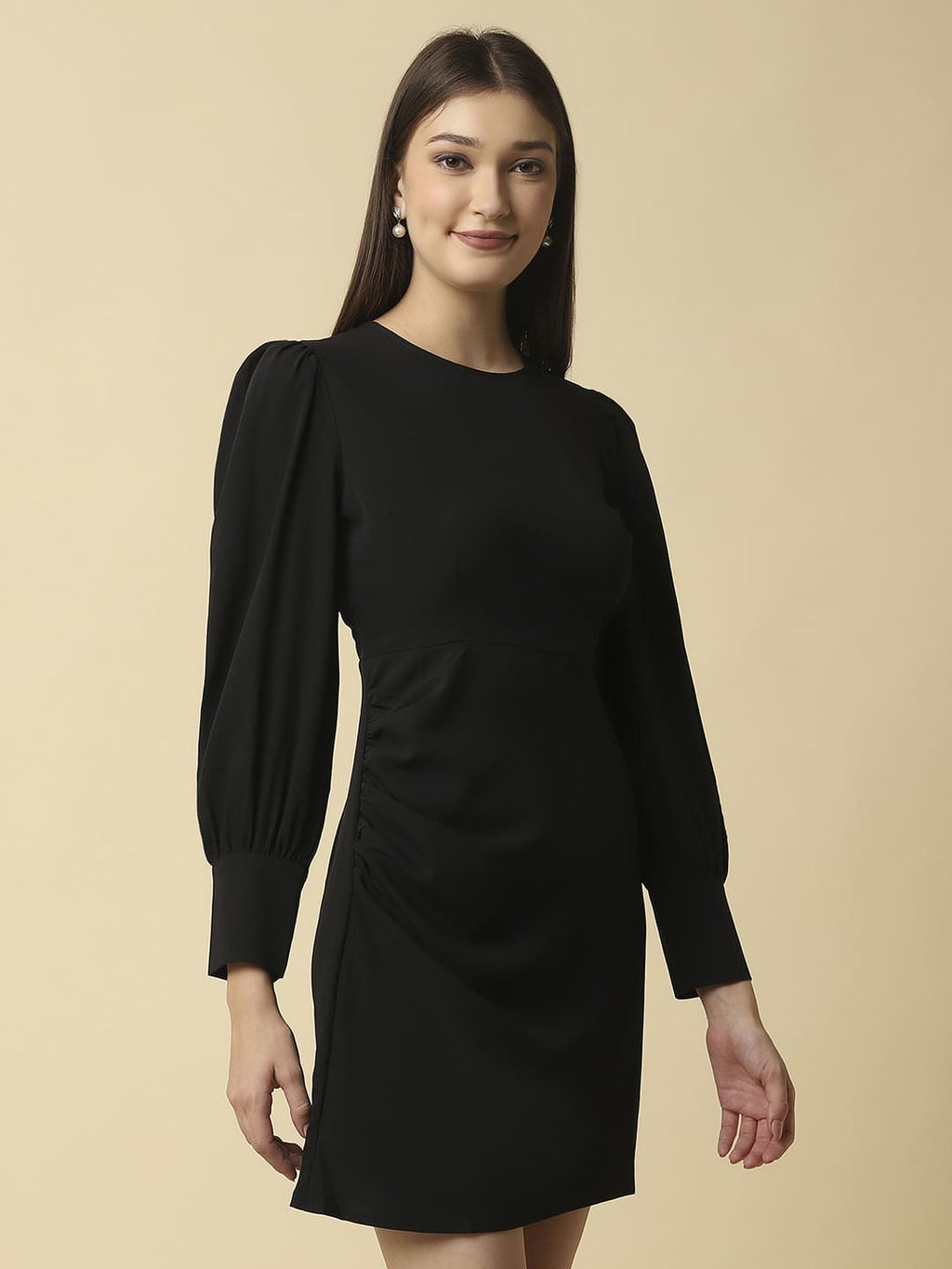 Woman wearing Raassio black ruched short dress with long puff sleeves facing front right side