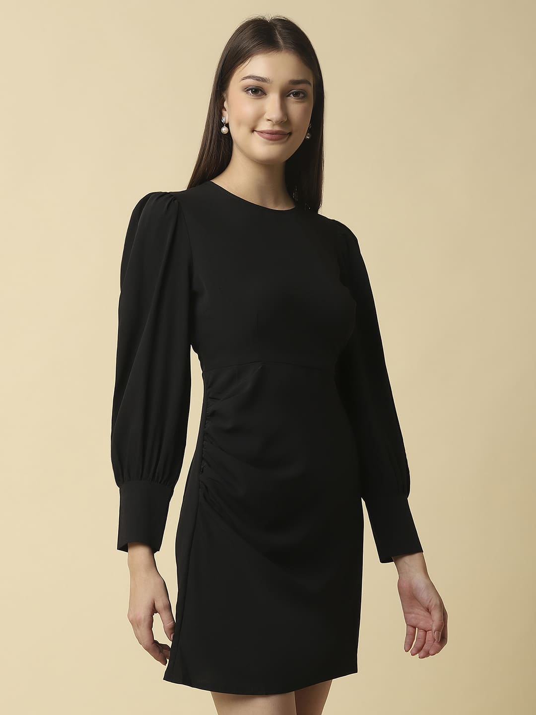 Woman wearing Raassio black ruched short dress with long puff sleeves facing front right side