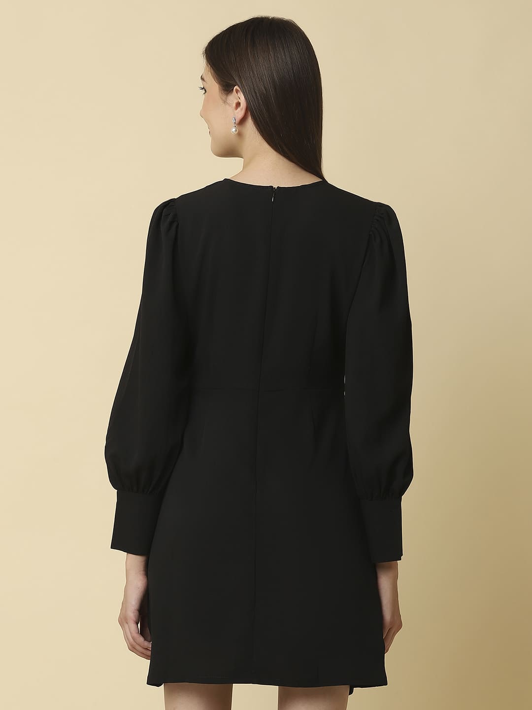 Woman wearing Raassio black ruched short dress with long puff sleeves facing  back