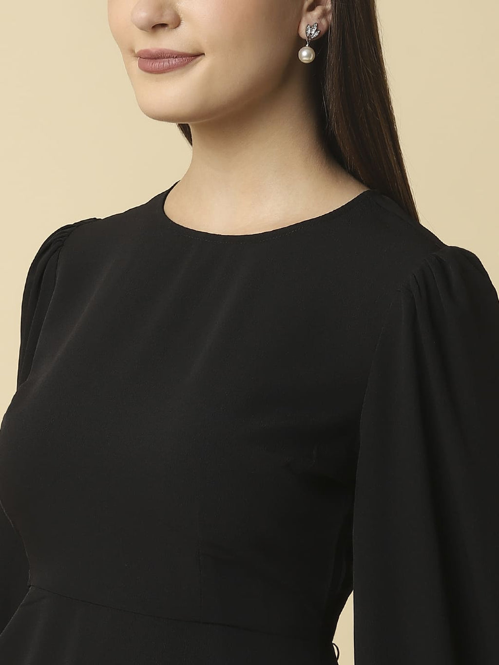 Woman wearing Raassio black ruched short dress with long puff sleeves facing front close up