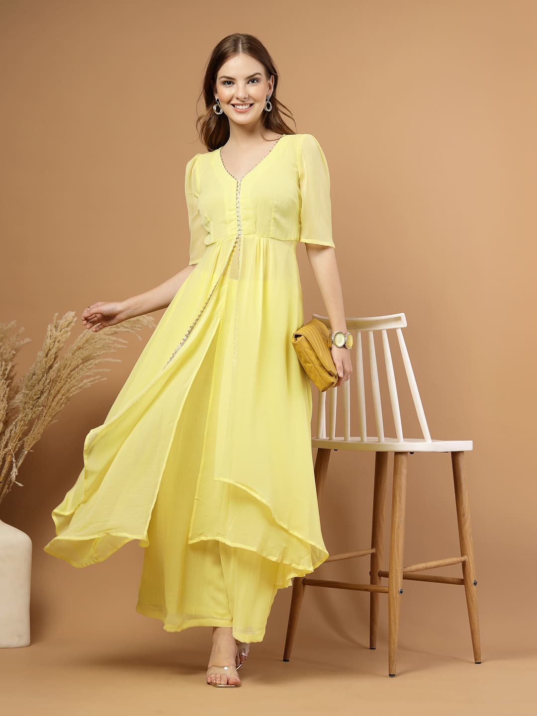 Yellow layered chiffon kurta with cotton lining, lace detailing at neck and flare, paired with flared bottom and side zip closure.