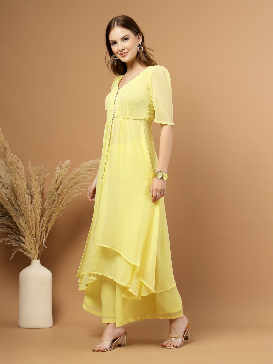 Yellow layered chiffon kurta with cotton lining, lace detailing at neck and flare, paired with flared bottom and side zip closure.