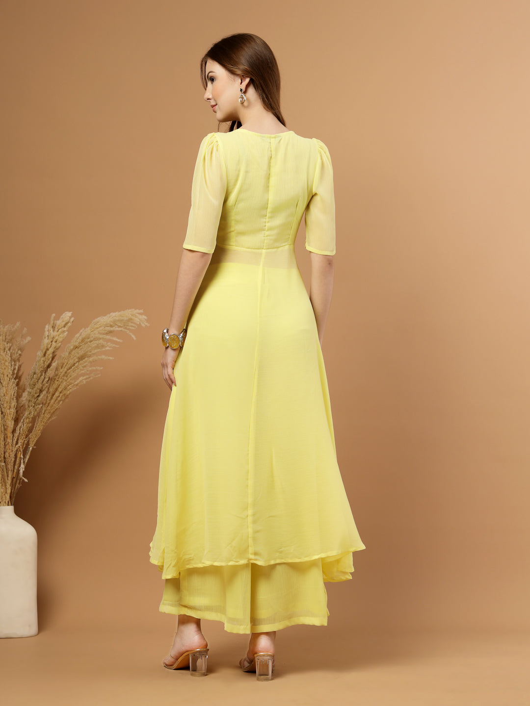 Yellow layered chiffon kurta with cotton lining, lace detailing at neck and flare, paired with flared bottom and side zip closure.