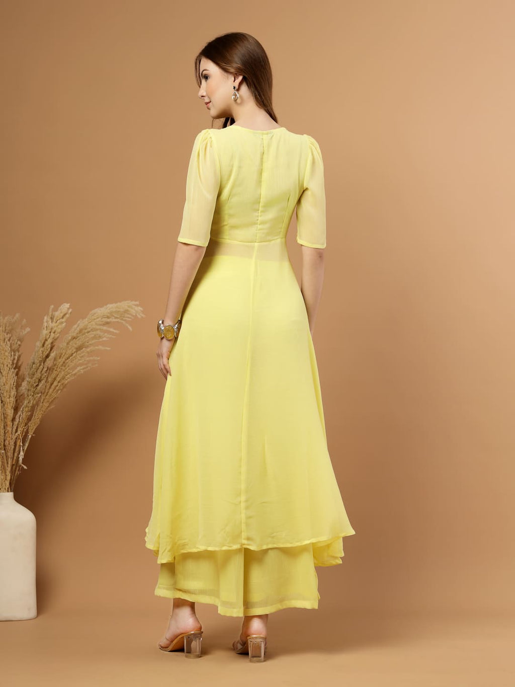 Yellow layered chiffon kurta with cotton lining, lace detailing at neck and flare, paired with flared bottom and side zip closure, back view