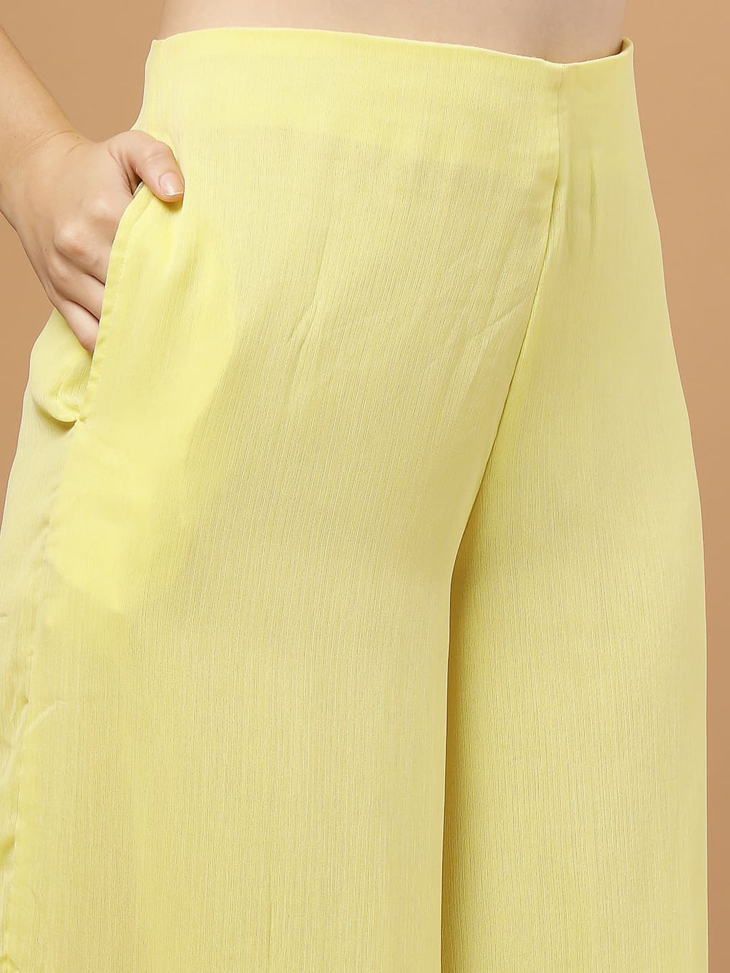 Yellow layered chiffon kurta with cotton lining, lace detailing at neck and flare, paired with flared bottom and side zip closure, close up view of the pant.