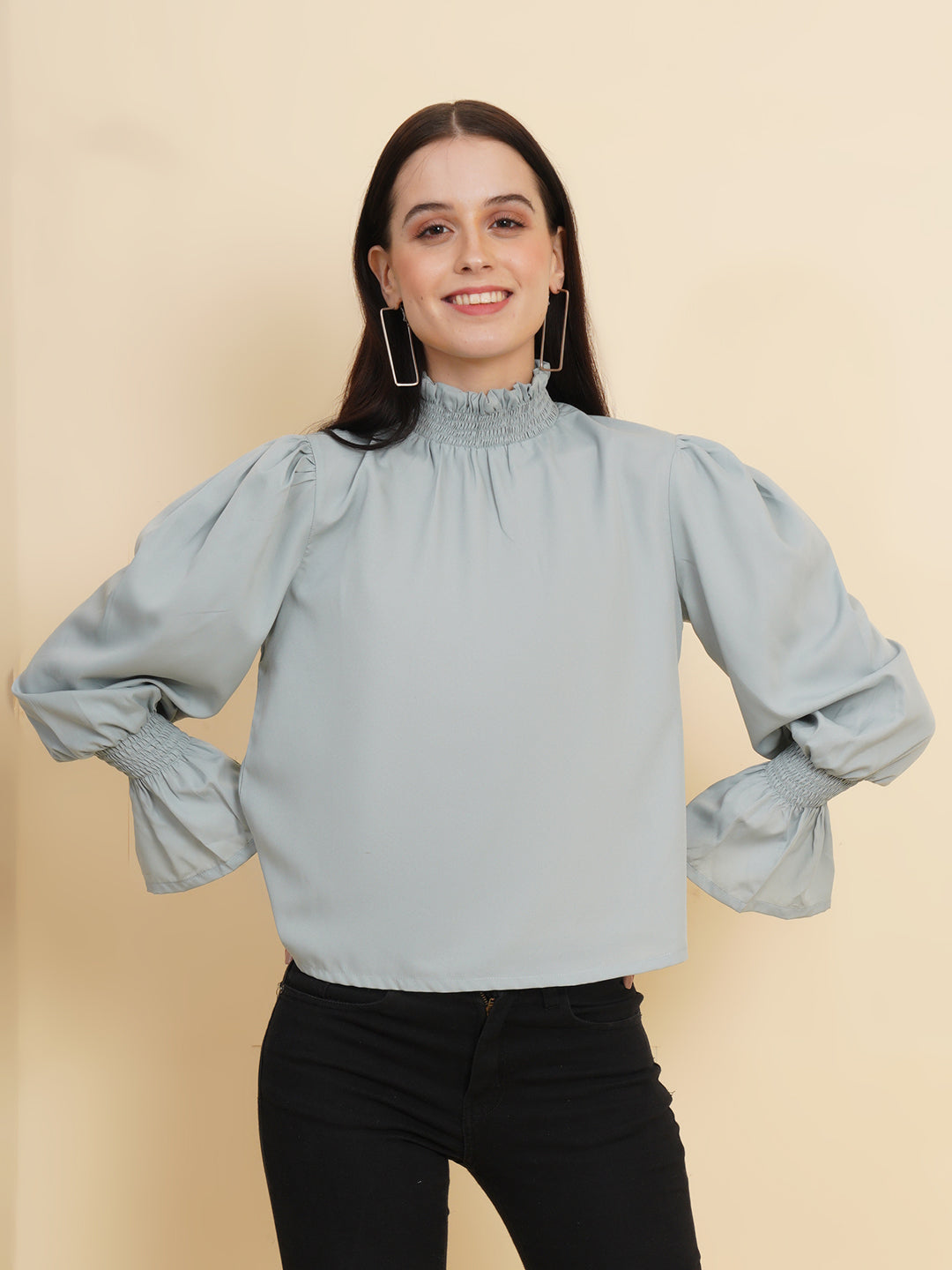 A stylish women's top in a soft shade of grey. The top features smocked detailing on both the full sleeves and the neck band, adding a touch of elegance and texture to the design.
