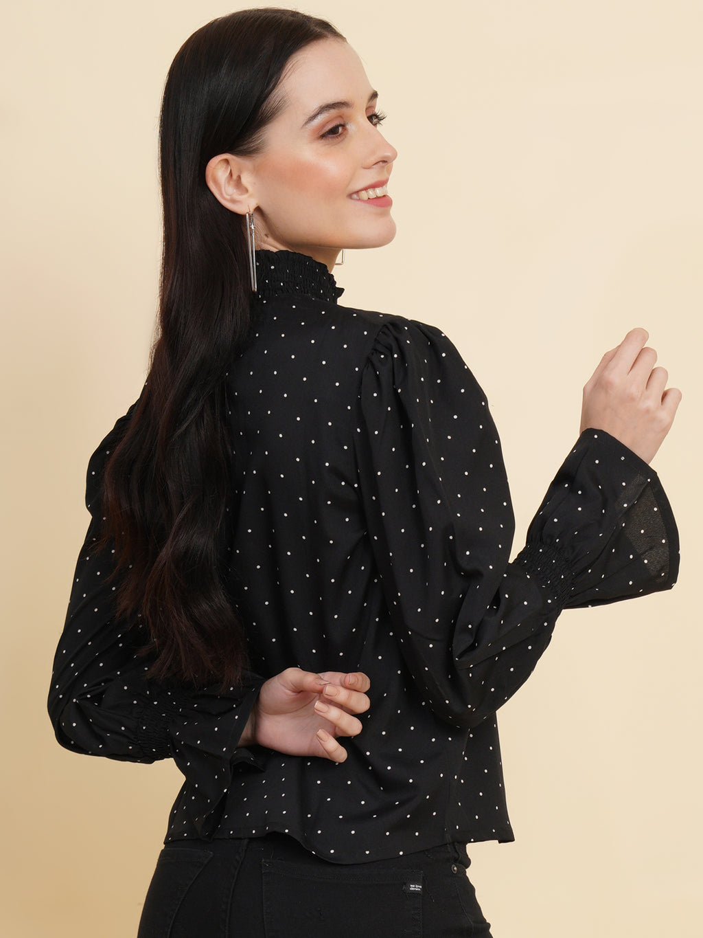 An elegant black women's top with a stylish dotted print. The top features a smocked neck and sleeves, adding a touch of sophistication and charm to your outfit