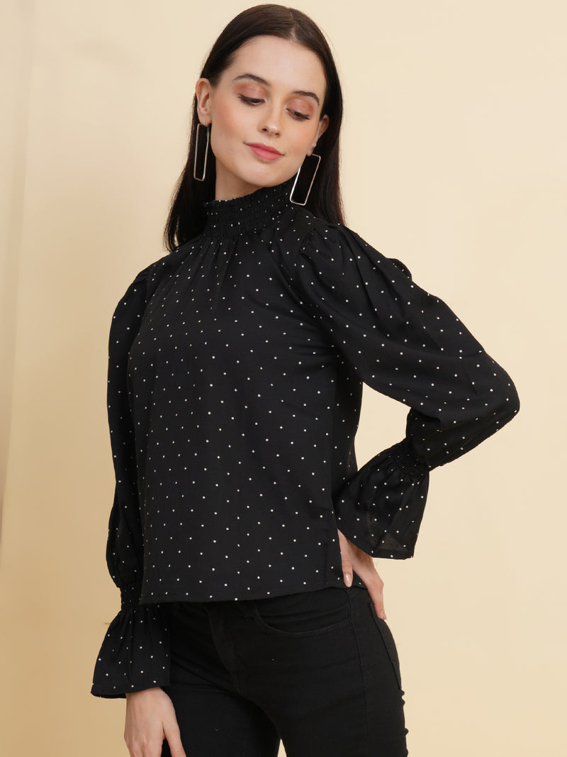An elegant black women's top with a stylish dotted print. The top features a smocked neck and sleeves, adding a touch of sophistication and charm to your outfit
