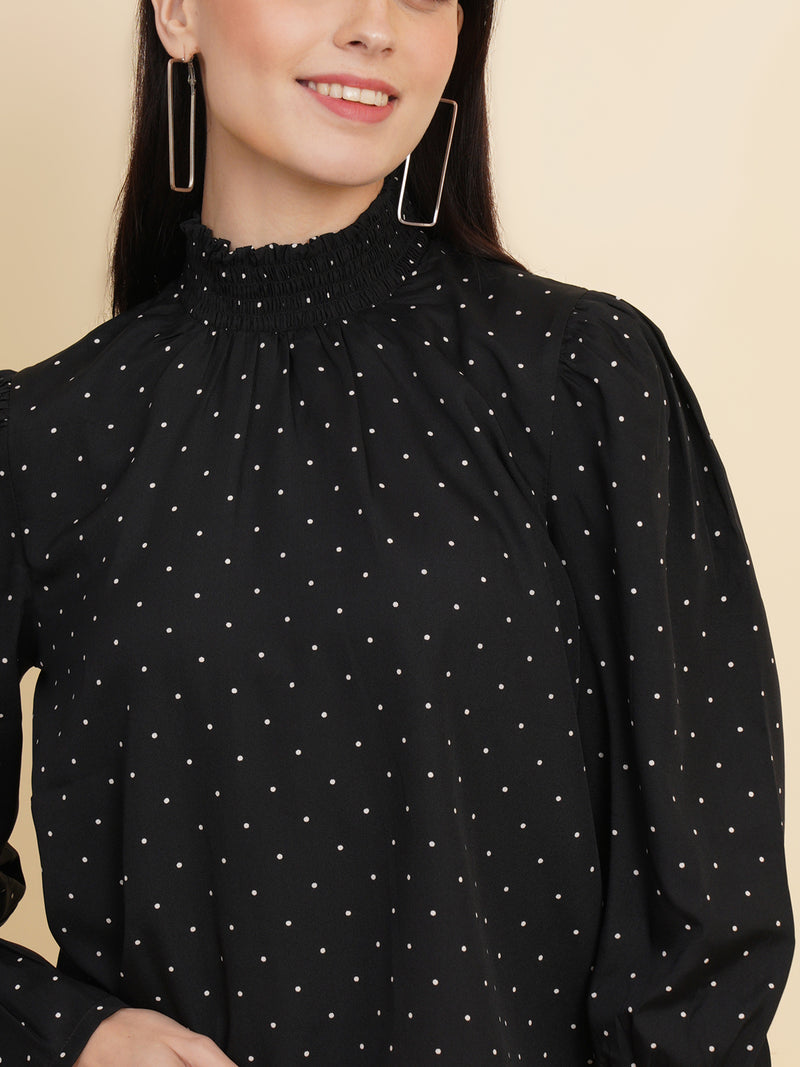 An elegant black women's top with a stylish dotted print. The top features a smocked neck and sleeves, adding a touch of sophistication and charm to your outfit