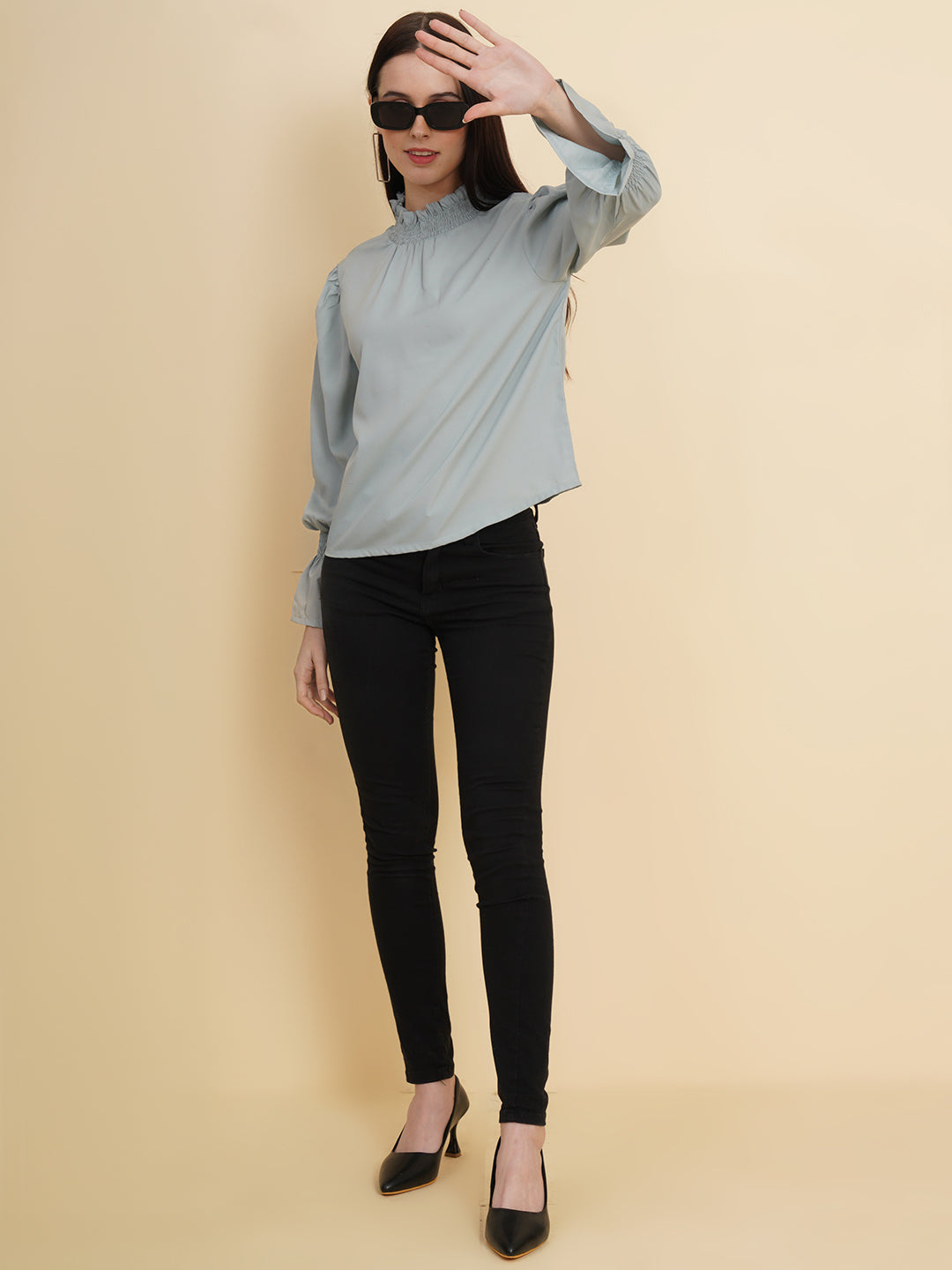 A stylish women's top in a soft shade of grey. The top features smocked detailing on both the full sleeves and the neck band, adding a touch of elegance and texture to the design.