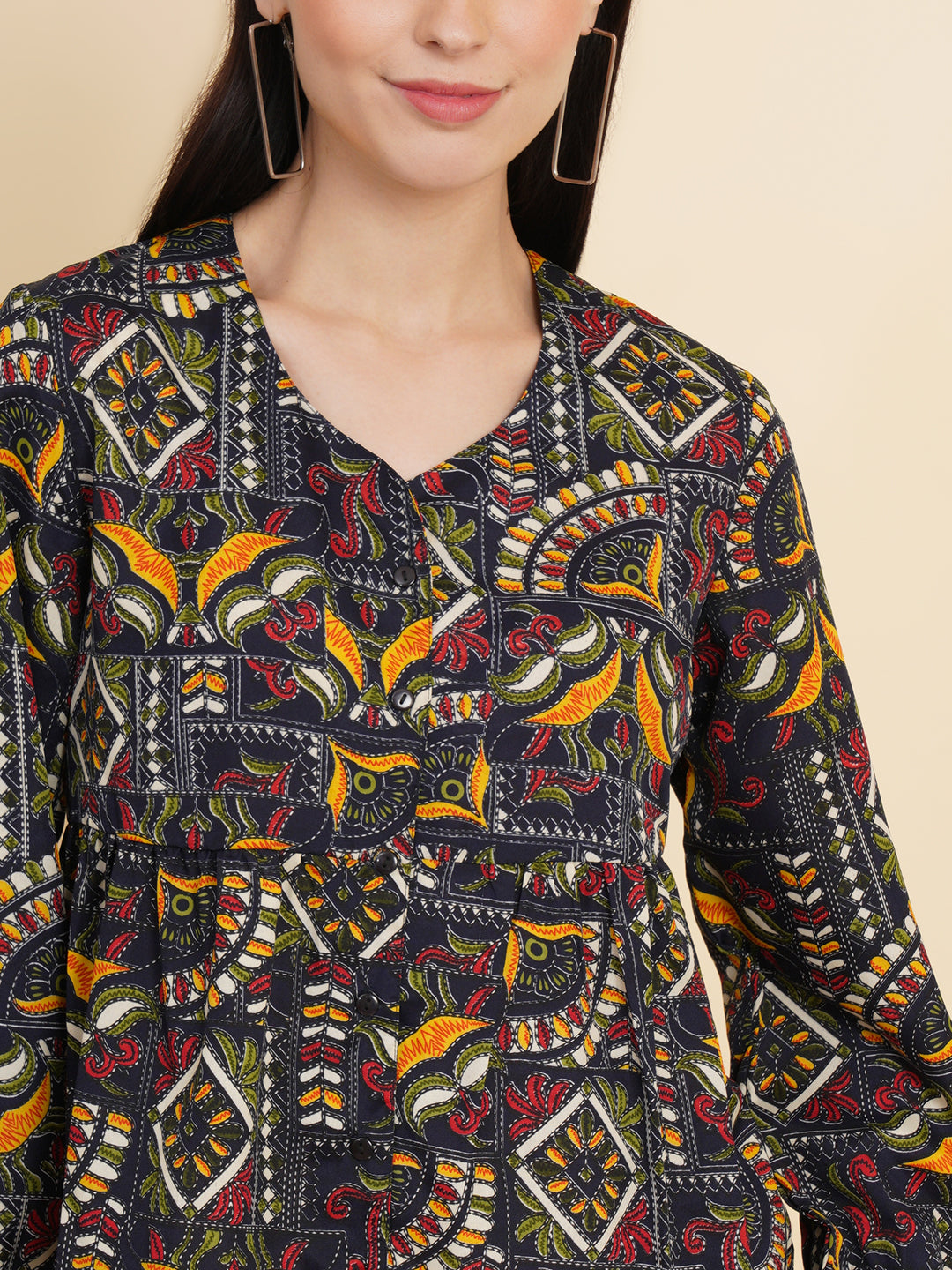 A vibrant and stylish women's top with a multi-color ethnic print. The top features full sleeves and is made with high-quality fabric. The print consists of various intricate patterns and colors, creating a visually appealing and unique design. The top is suitable for casual or semi-formal occasions, adding a touch of cultural flair to any outfit