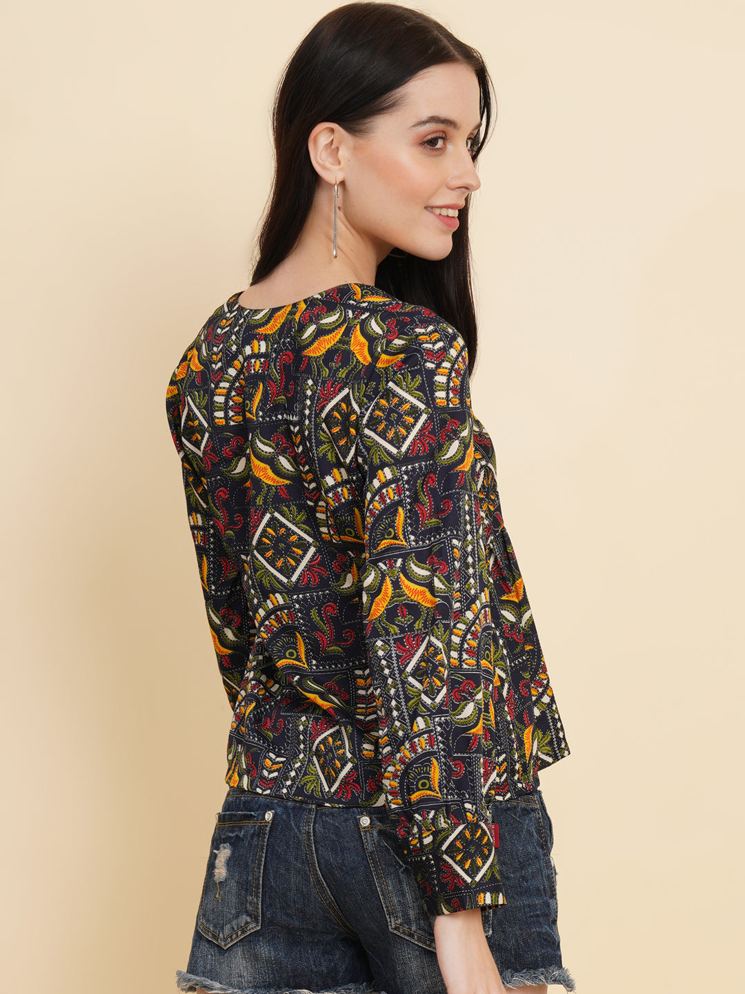 A vibrant and stylish women's top with a multi-color ethnic print. The top features full sleeves and is made with high-quality fabric. The print consists of various intricate patterns and colors, creating a visually appealing and unique design. The top is suitable for casual or semi-formal occasions, adding a touch of cultural flair to any outfit