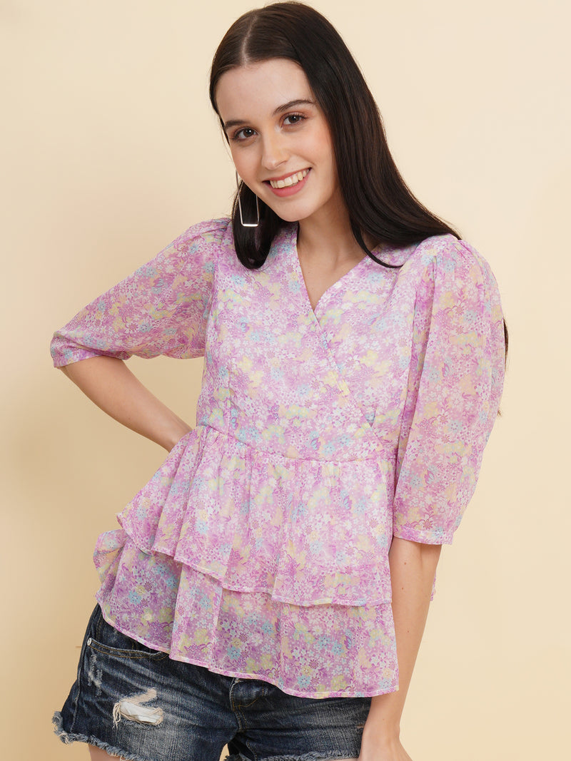  A vibrant purple women's top adorned with beautiful floral patterns. It features double ruffle detailing, creating an elegant and feminine look. The top is fully lined, providing comfort and a smooth fit. Perfect for adding a touch of color and style to any outfit